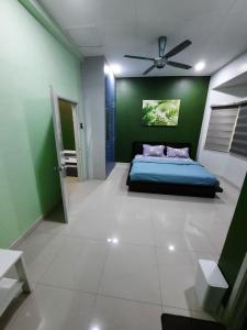 um quarto com uma cama azul e uma parede verde em HOMESTAY DR. Z (MUSLIM HOMESTAY) em Klang