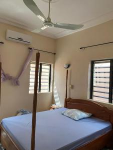 Schlafzimmer mit einem Bett und einem Deckenventilator in der Unterkunft Bethel House 2 Villas in Abomey-Calavi