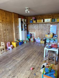 Y Doc at World Horizons Community Hub في ليانيلي: غرفة مع أرضية خشبية وغرفة بها غرفة