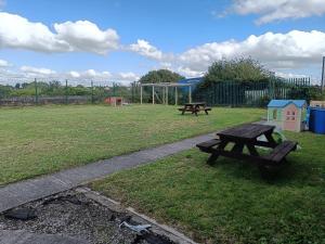 un parque con dos mesas de picnic en el césped en Y Doc at World Horizons Community Hub, en Llanelli