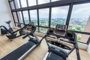 een fitnessruimte met 2 loopbanden en 2 hometrainers bij The Apple Premier Suites Melaka in Melaka