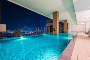 - une piscine sur le toit d'un immeuble avec vue sur la ville dans l'établissement The Apple Premier Suites Melaka, à Malacca