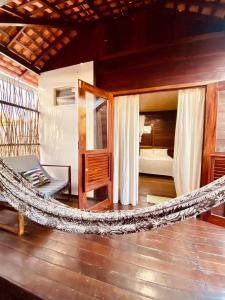 a hammock in a room with a bedroom at Chalés Paradise in Atins
