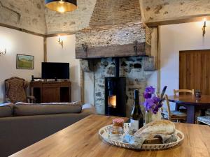 a living room with a table and a fireplace at Petit Clos Gîte Rural in Saint-Jean-de-Duras