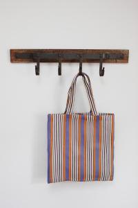 un sac fourre-tout suspendu à une étagère en bois dans l'établissement Millgate Cottage in the heart of Richmond, à Richmond 26 autres photos