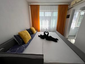 łóżko, na którym leży para czarnych butów w obiekcie Miha modern and central apartament w mieście Arad