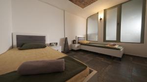 a bedroom with two beds and a sink and two windows at Hostel Dera in Pristina