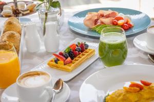 un tavolo ricoperto di piatti di prodotti per la colazione e bevande di Lido Palace - The Leading Hotels of the World a Riva del Garda