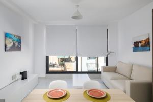 - un salon avec une table et un canapé dans l'établissement Cosy, Modern 1 Bedroom Apartment (Qawra), à San Pawl il-Baħar
