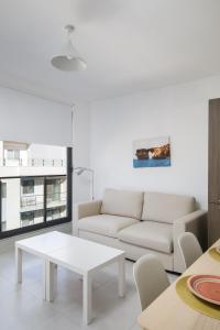 - un salon avec un canapé blanc et une table dans l'établissement Cosy, Modern 1 Bedroom Apartment (Qawra), à San Pawl il-Baħar