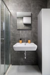 La salle de bains est pourvue d'un lavabo et d'une douche. dans l'établissement Cosy, Modern 1 Bedroom Apartment (Qawra), à San Pawl il-Baħar