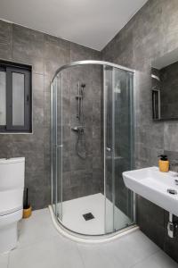 La salle de bains est pourvue d'une douche, de toilettes et d'un lavabo. dans l'établissement Cosy, Modern 1 Bedroom Apartment (Qawra), à San Pawl il-Baħar