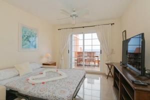a bedroom with a bed and a flat screen tv at Apartamento Sara en el Veril del Duque - Sara Vacation in Adeje