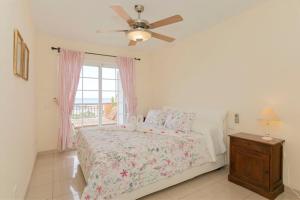 una camera con letto, ventilatore a soffitto e finestra di Apartamento Sara en el Veril del Duque - Sara Vacation ad Adeje