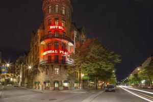 a tall building with a red neon sign on it at Crystal Plaza Hotel in Stockholm