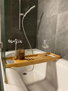 ein Badezimmer mit einer Badewanne mit einem Weinglas in der Unterkunft Stylish two-floor apartment in a heart of Basel in Basel