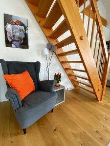ein Wohnzimmer mit einem Stuhl und einer Treppe in der Unterkunft Stylish two-floor apartment in a heart of Basel in Basel