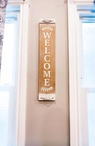 um sinal de boas-vindas numa parede ao lado de uma porta em The Griffon House em Niagara Falls