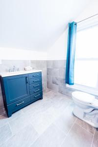 a bathroom with a blue sink and a toilet at The Griffon House in Niagara Falls