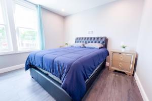 a bedroom with a bed with a blue comforter at The Griffon House in Niagara Falls