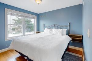 a blue bedroom with a bed and a window at Hampton Beach Beauty in Hampton
