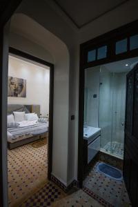 a bedroom with a bed and a bathroom with a shower at RIAD DOUIRTNA in Marrakech