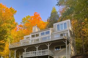 une maison entourée d'une terrasse dans les bois dans l'établissement Beautiful Four Season Mountain Retreat, à Campton