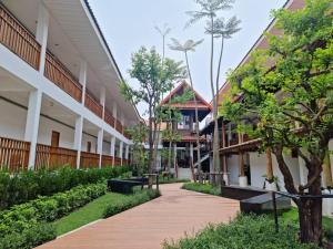 a courtyard of a building with trees and a sidewalk at A Day In Phetchabun in Phetchabun