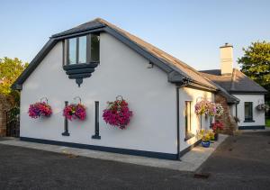 a white building with flower baskets on it at Ashville House B&B Tralee in Tralee