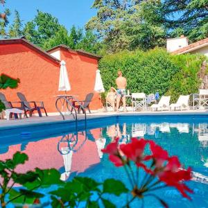 un uomo e un cane seduti accanto a una piscina di Posada Mia Nonna a Villa General Belgrano