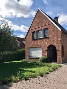 a brick house with a window and a driveway at De Bijenkorf in Damme