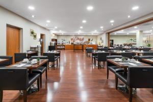 Un comedor con mesas y sillas de madera. en Crisol Riosol, en León