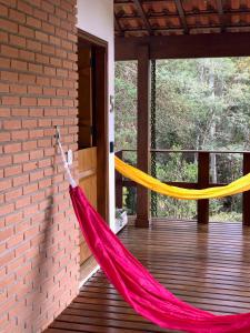 eine rote und gelbe Hängematte auf einer Veranda in der Unterkunft Barra do Bié Suítes in Cunha