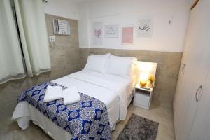 ein kleines Schlafzimmer mit einem Bett und einem Nachttisch in der Unterkunft Studio Manaíra #806 por Carpediem in João Pessoa