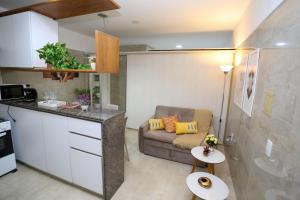 Il comprend un petit salon avec un canapé et une cuisine. dans l'établissement Studio Manaíra #806 por Carpediem, à João Pessoa