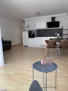 Il comprend un salon avec une table et une cuisine. dans l'établissement Appartement by Luis, à Burgheim
