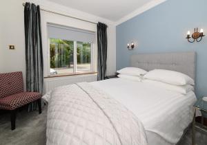 a bedroom with a large white bed and a window at Ashville House B&B Tralee in Tralee