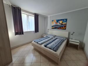 ein Schlafzimmer mit einem Bett in einem Zimmer in der Unterkunft Apartments Helena in Umag