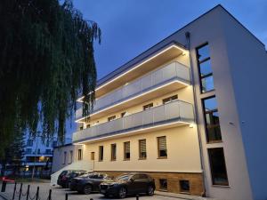 two cars parked in front of a building at Apartamenty ELIASZ in Ustronie Morskie
