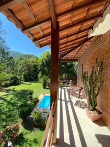 eine Terrasse mit einer hölzernen Pergola und einem Pool in der Unterkunft Recanto de Moriá in Penedo