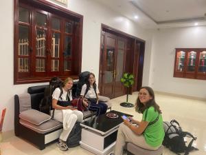 tres mujeres sentadas en una habitación jugando un videojuego en Hanoi Airport Suites Hostel & Travel en Hanói