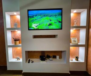 a flat screen tv on a wall above a fireplace at Green Hills by Rent a car MI in Podgorica