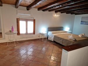 a bedroom with a bed and two tables and a window at Le Stanze di Marta in Cefalù