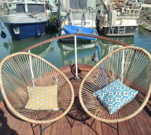 duas cadeiras com almofadas sentadas em cima de um barco em Capitaine Zephyr em Beaucaire