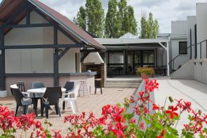 Cette maison dispose d'une terrasse avec une table et des chaises. dans l'établissement Hôtel ibis Styles Auxerre Nord, à Auxerre