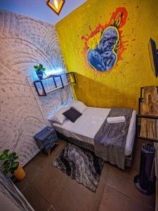 Habitación con cama y pintura en la pared en Urban Hostal Bar, en Bucaramanga