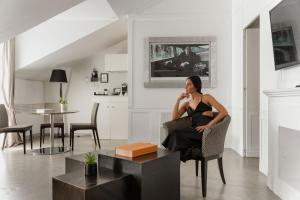a woman sitting in a chair talking on a cell phone at Montenapoleone Suites in Milan