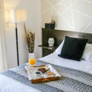 a tray of food and a glass of orange juice on a bed at Posada Mia Nonna in Villa General Belgrano