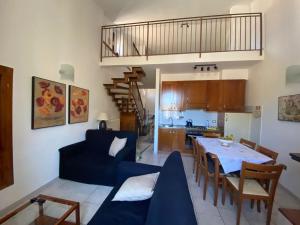 a living room and kitchen with a blue couch and a table at Mameli Suite in Spoleto