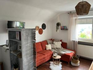 sala de estar con sofá rojo y ventana en Odenwald Heaven, en Erbach